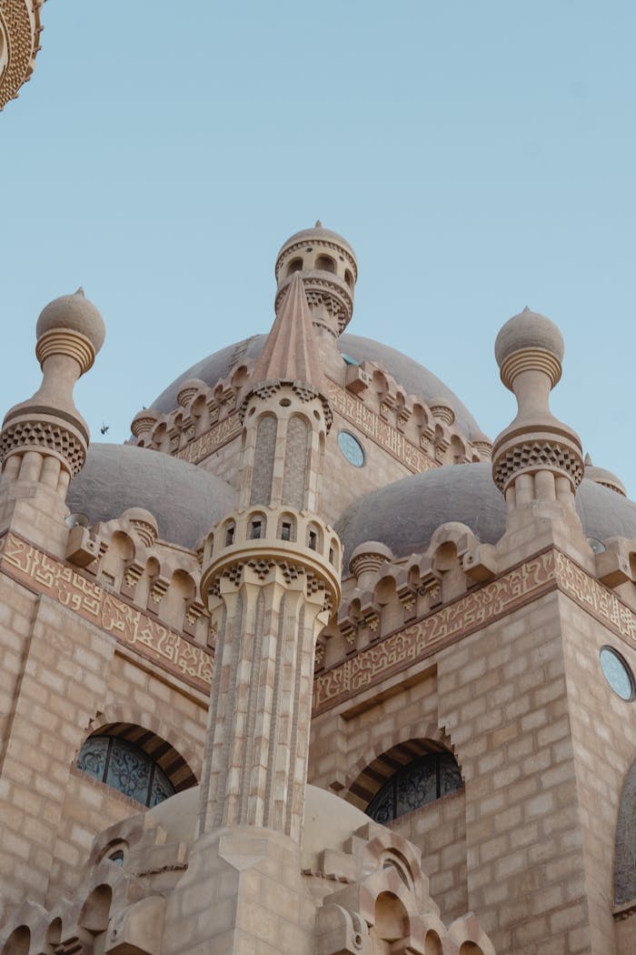 A beautifully detailed mosque with intricate Islamic architectural design captured at dusk.